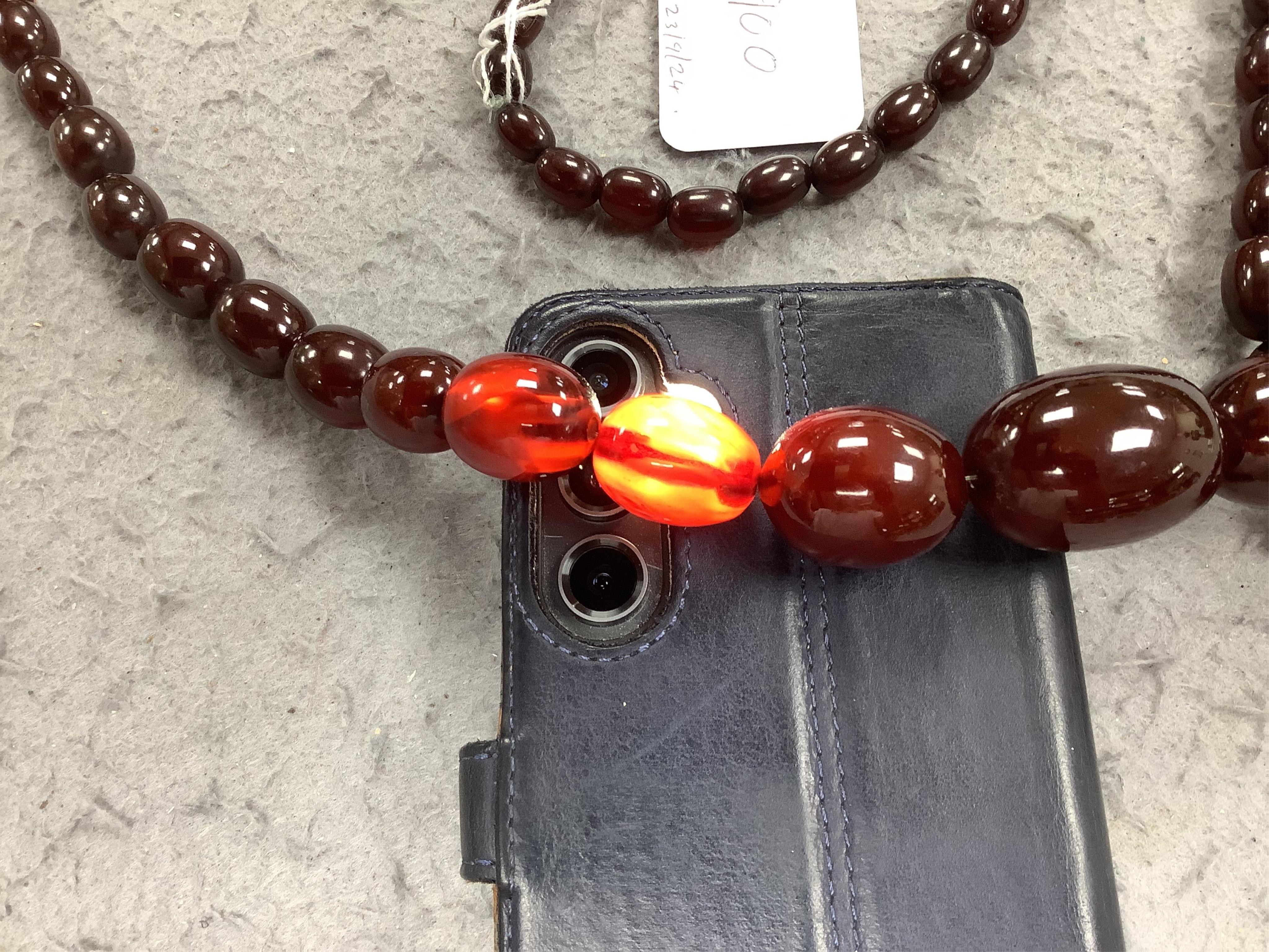 A single strand graduated simulated cherry amber oval bead necklace, 98cm, gross weight 140 grams. Condition - fair to good